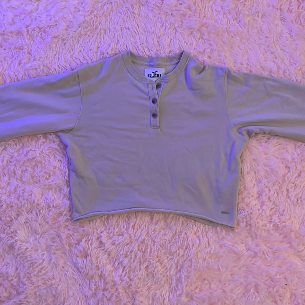 Cropped long sleeve shirt with buttons at the top.